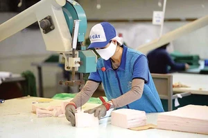 Cắt khẩu trang bằng máy tại một nhà máy thuộc hệ thống của Tập đoàn Dệt may Việt Nam (Vinatex)