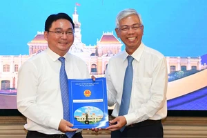Phó Chủ tịch UBND TPHCM Võ Văn Hoan trao quyết định cho ông Nguyễn Trần Bình. Ảnh: VIỆT DŨNG 