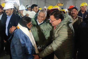 Thủ hiến bang Uttarakhand của Ấn Độ (phải, phía trước) thăm hỏi sức khỏe một công nhân (trái, phía trước) vừa được giải cứu. Ảnh: TTXVN