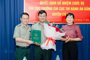 Cục trưởng Cục THADS TPHCM Nguyễn Văn Hòa cùng lãnh đạo huyện Củ Chi tặng hoa chúc mừng ông Phan Văn Phước. Ảnh: CẨM TÚ 
