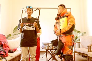 Anh Temba Bhote (bên trái) - người 10 lần chinh phục đỉnh Everest hướng dẫn cách mặc trang phục chuyên dùng khi leo núi tuyết cho bạn trẻ tham dự buổi giao lưu