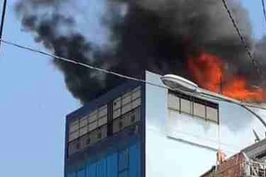 Ngọn lửa bùng cháy dữ dội ở tầng thượng tòa nhà.