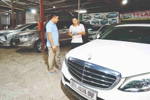 Nhân viên một công ty cho thuê xe tự lái trên đường Cao Lỗ, quận 8, TPHCM, giới thiệu mẫu xe cho khách đến thuê. Ảnh: HOÀNG HÙNG
