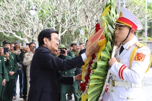 Nguyên Chủ tịch nước Trương Tấn Sang chỉnh vòng hoa trước khi dâng lên trước Tượng đài Tổ quốc ghi công tại Nghĩa trang Liệt sỹ quốc gia Vị Xuyên. Ảnh: VĂN NGHỊ