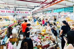 Du khách Đài Loan (Trung Quốc) chọn mua cà phê và trái cây sấy khô Tây Nguyên tại chợ An Đông, TPHCM. Ảnh: THI HỒNG
