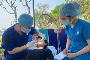 Bác sĩ Bệnh viện Răng Hàm Mặt Trung ương TPHCM đang thăm khám răng cho một học sinh