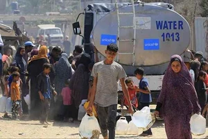 Người dân Palestine lấy nước từ một xe bồn chở nước của UNICEF tại Deir el-Balah ở miền Trung Dải Gaza. Ảnh: AHRAM ONLINE 