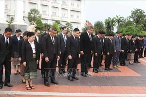 Nghi thức treo cờ rủ tại Văn phòng Thủ tướng Lào. Ảnh: TTXVN.