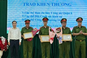 Thiếu tướng Mai Hoàng, Phó Giám đốc Công an TPHCM cùng Bí thư Quận ủy quận 6 Ma Xuân Việt trao giấy khen và hoa cho các đơn vị phá án