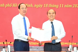 Lãnh đạo Thành ủy TPHCM chúc mừng đồng chí Trần Văn Bảy. Ảnh: VIỆT DŨNG