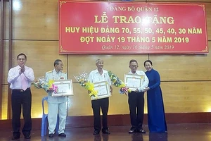 Phó Bí thư Thành ủy Võ Thị Dung trao huy hiệu 70 năm tuổi Đảng cho các đảng viên