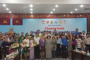  Chủ tịch Ủy ban MTTQ Việt Nam TPHCM Tô Thị Bích Châu và bà Phimpha Keomixay, Tổng Lãnh sự Lào tại TPHCM chụp hình kỷ niệm với các gia đình Việt nhận sinh viên Lào về sinh sống