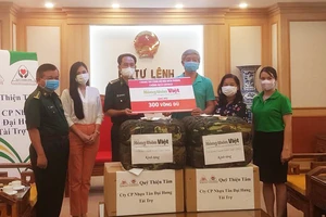 Đại diện Tạp chí Nông thôn Việt trao bảng tượng trưng ủng hộ 300 võng dù
