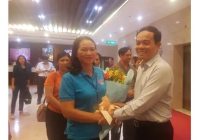 Đồng chí Trần Lưu Quang tặng hoa chúc mừng đoàn đại biểu già làng, trưởng bản tiêu biểu tỉnh Cao Bằng đến TPHCM
