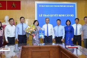 Phó Chủ tịch UBND TPHCM Ngô Minh Châu trao quyết định cho bà Võ Thị Chính. Ảnh: HOÀI NAM