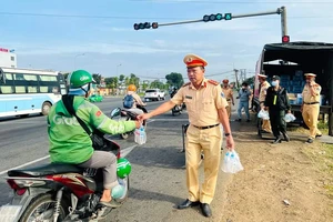 Đồng Nai: Cảnh sát giao thông phát nón bảo hiểm và nước cho người dân về quê ăn tết
