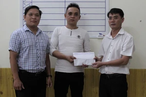 Đại diện Báo SGGP tại miền Trung và chính quyền địa phương trao tiền hỗ trợ cho gia đình cháu Huy 