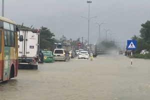 Nước ngập sâu một đoạn gần 100m trên tuyến Quốc lộ 1A tại huyện Phú Ninh (tỉnh Quảng Nam) khiến giao thông gặp khó khăn. Ảnh: NGUYỄN CƯỜNG