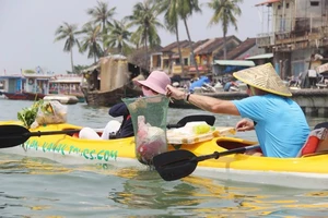 Hai du khách tham gia tour vớt rác trên sông Hoài (TP Hội An, tỉnh Quảng Nam)