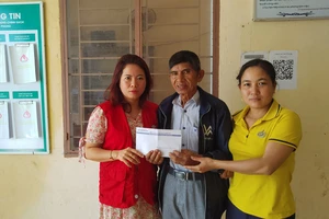 Đại diện xã Tiên Phong trao tiền của bạn đọc báo SGGP hỗ trợ cho gia đình ông Nguyễn Văn Miết