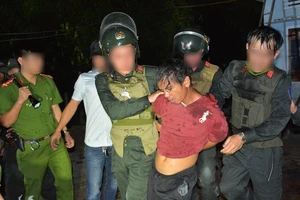 Đối tượng Trần Văn Xanh bị lực lượng công an bắt giữ khi cố thủ trong nhà