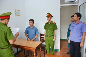 Lực lượng công an tống đạt quyết định tạm giam đối với Nguyễn Hoàng Minh. Ảnh M.T.