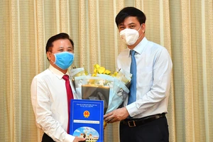 Phó Chủ tịch UBND TPHCM Lê Hoà Bình trao quyết định cho đồng chí Nguyễn Hữu Tín. Ảnh: VIỆT DŨNG