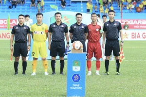 Trọng tài Lê Đức Cảnh (thứ 3, bên phải sang) có quyết định gây tranh cãi ở trận đấu giữa Hòa Bình - Bình Thuận. ẢNH: MINH HOÀNG 
