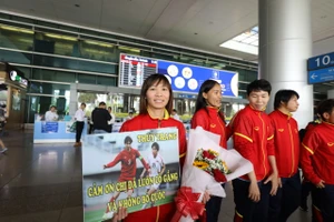 Tuyển thủ Thùy Trang bên cạnh món quà của người hâm mộ Việt Nam dành tặng ở sân bay Tân Sơn Nhất. ẢNH: DŨNG PHƯƠNG 