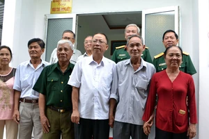 Các đại biểu chụp hình lưu niệm bên Nhà đồng đội vừa cất cho đồng chí Thượng tá Nguyễn Chiến Lang