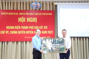 Đồng chí Phạm Quốc Bảo (phải) tặng quà lưu niệm cho lãnh đạo huyện Củ Chi tại hội nghị ngành điện TPHCM gắn kết với cấp ủy, chính quyền địa phương