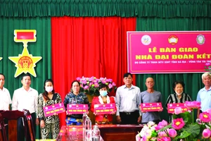 Ông Nguyễn Hữu Lĩnh (giữa), Phó giám đốc Công ty Xổ số kiến thiết Bà Rịa - Vũng Tàu trao nhà cho các gia đình nghèo khó khăn