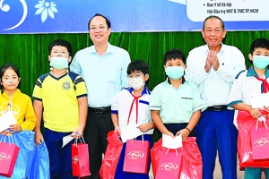 Nguyên Phó Thủ tướng Thường trực Trương Hòa Bình và Phó Bí thư Thành ủy TPHCM Nguyễn Hồ Hải tặng quà học sinh. Ảnh: VIỆT DŨNG