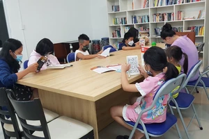 Cư dân và các em nhỏ tại chung cư Belleza (phường Phú Mỹ, quận 7, TPHCM) đọc sách tại CLB Thanh thiếu niên