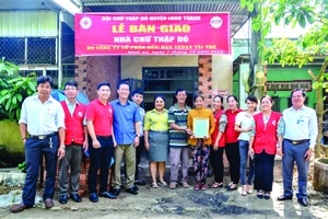 Bà Nguyễn Thu Thủy (thứ 6 từ trái sang) - đại diện Vedan trao nhà cho gia đình bà Huỳnh Thị Hồng tại xã Bình An