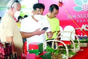 Người dân tìm hiểu các sản phẩm từ sâm Ngọc Linh được trưng bày tại Phiên chợ sâm Ngọc Linh ở Kon Tum 