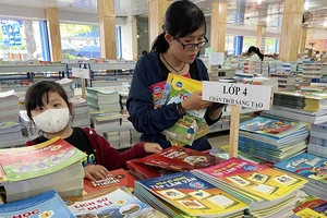 Phụ huynh mua sách giáo khoa lớp 4 năm học 2023-2024 tại một cửa hàng sách ở TPHCM. Ảnh: CAO THĂNG
