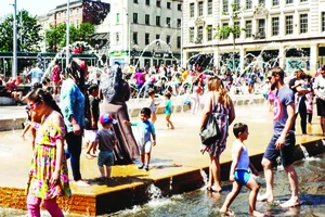 Trẻ em chơi với nước trong đợt nắng nóng bất thường ở châu Âu. Ảnh: The Guardian
