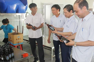 Anh Nguyễn Văn Tuyến (thứ hai, từ trái sang) giới thiệu sản phẩm nước mắm Ba Làng với khách hàng