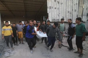 Chuyển thi thể nạn nhân thiệt mạng sau cuộc không kích của Israel xuống thành phố Rafah ở Dải Gaza. Ảnh: TTXVN 