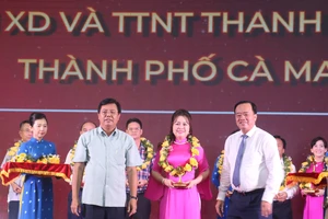 Bí thư Tỉnh ủy Cà Mau Nguyễn Tiến Hải (trái) và Chủ tịch UBND tỉnh Huỳnh Quốc Việt (phải) trao biểu trưng và hoa cho doanh nghiệp tiêu biểu tỉnh Cà Mau năm 2023