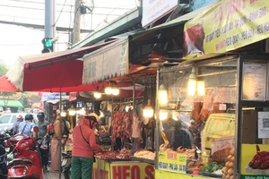 Người đi đường dựng xe trên đường đứng mua thịt heo tại chợ tự phát Hiệp Bình, TP Thủ Đức, TPHCM