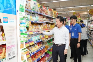 Ông Nguyễn Anh Đức, Tổng Giám đốc Saigon Co.op, kiểm tra hàng hóa tại Co.opmart. Ảnh: HOÀNG HÙNG
