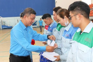Ông Trần Đoàn Trung, Phó Chủ tịch Thường trực LĐLĐ TPHCM, trao quà tặng công nhân khó khăn tại quận 7 nhân Tháng Công nhân lần thứ 16
