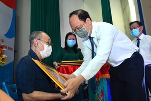 Phó Bí thư Thành ủy TPHCM Nguyễn Hồ Hải trao Huy hiệu 60 năm tuổi Đảng cho đồng chí Phạm Văn Sáu. Ảnh: VIỆT DŨNG