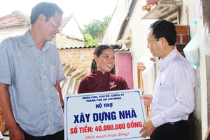 Đồng chí Nguyễn Văn Hiếu trao tiền hỗ trợ xây nhà cho chị Hồ Thị Bông, ở xã Phước Sơn (huyện Tuy Phước, Bình Định)