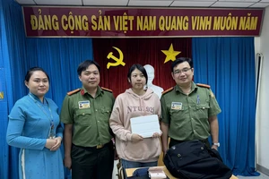 Cô Huang Huy Yu xúc động nhận lại tài sản từ Thiếu tá Trần Minh Cường (bìa phải) 