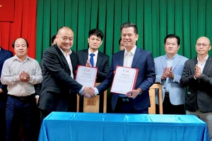 Ông Nguyễn Việt Dũng (trái), Giám đốc Trung tâm Truyền thông TN -MT và ông Nguyễn Quốc Bảo, Chủ tịch Câu lạc bộ Bất động sản Việt Nam, ký kết thỏa thuận hợp tác