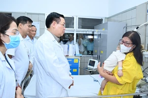 Chủ tịch Quốc hội Vương Đình Huệ thăm hỏi các nạn nhân vụ cháy đang được điều trị tại bệnh viện Bạch Mai (Hà Nội). Ảnh: VIẾT CHUNG 