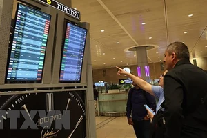 Hành khách theo dõi danh sách các chuyến bay bị hủy trên bảng thông báo tại Sân bay Quốc tế Ben Gurion ở Tel Aviv, Israel ngày 7/10. (Ảnh: AFP/TTXVN)